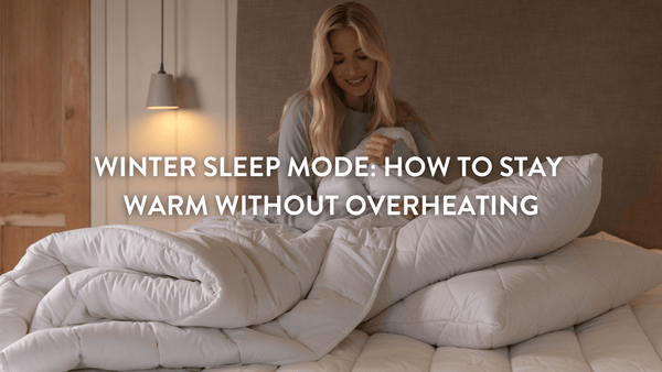 person sitting on a large double bed surrounded by wool duvet wool mattress topper and wool pillows from Putnams 