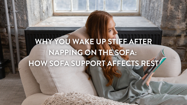 Person sittoing on a sofa reading supported by a Putnams lumbar support cushion.
