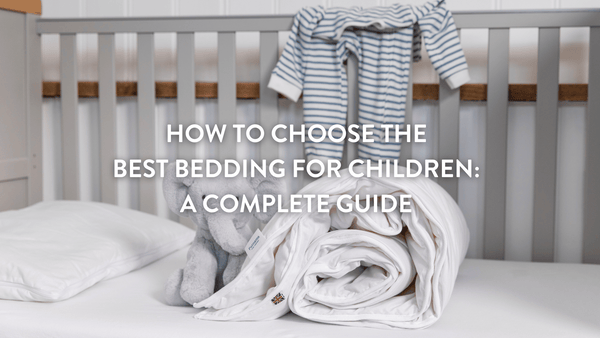 Rolled up children's duvet and cuddly grey elephant on a children's mattress in a cot