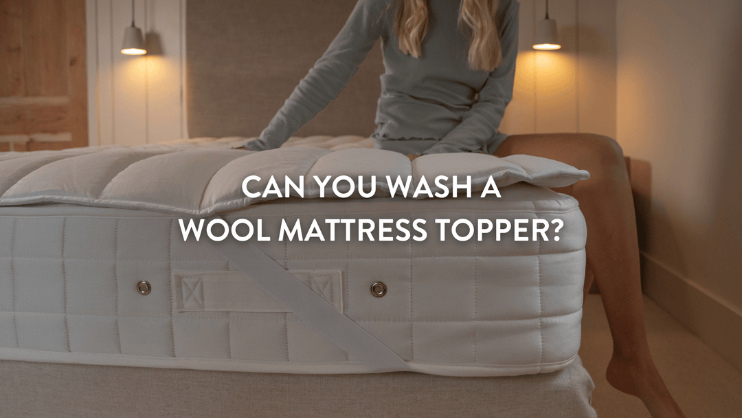 person sitting on a double bed with a Putnams wool mattress topper on the bed